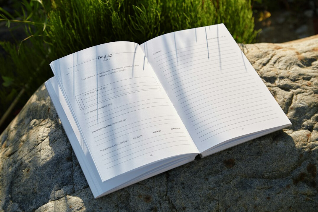 Hand writing notes in a notebook on a desk